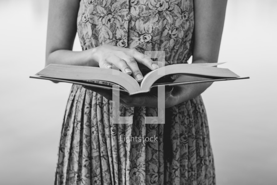 a torso of a woman reading a book 