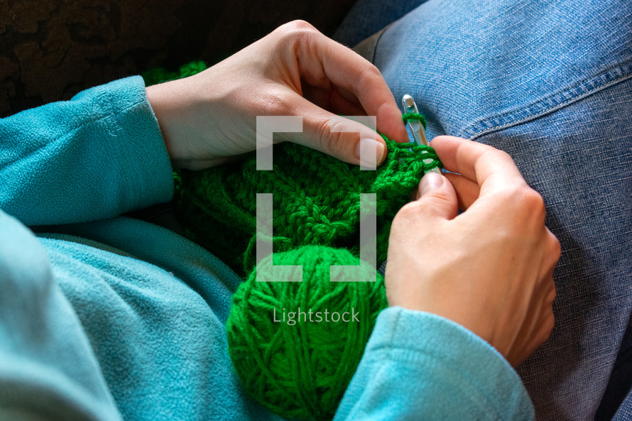 woman knitting green yarn 