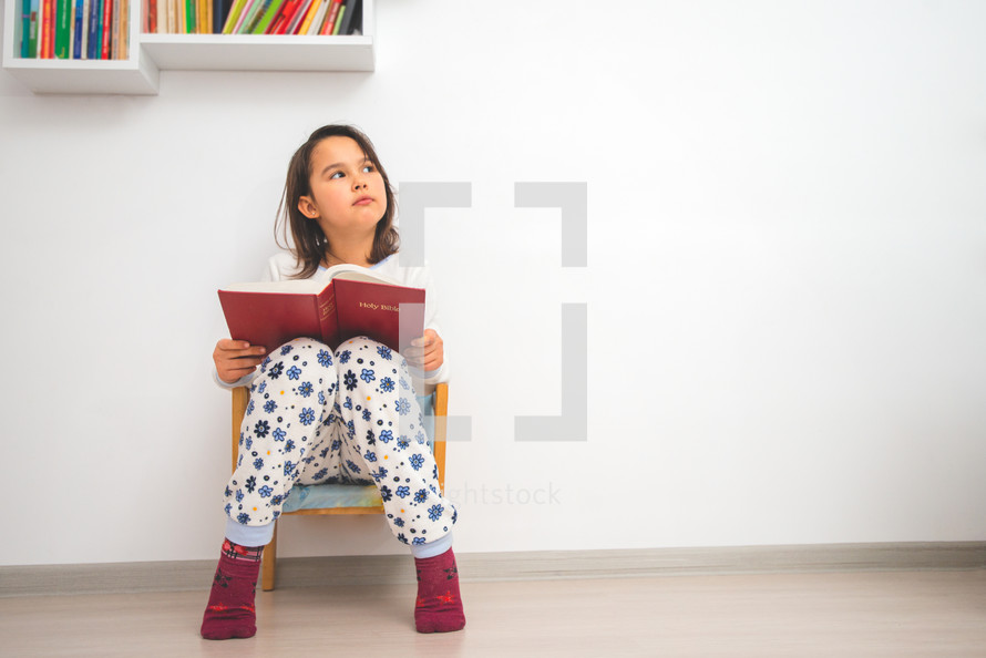 a little girl reading a Bible 