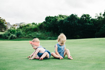 babies playing in grass