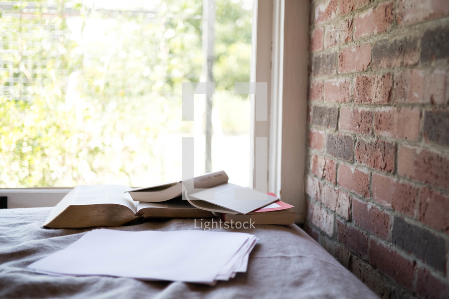 books on a table in a window 