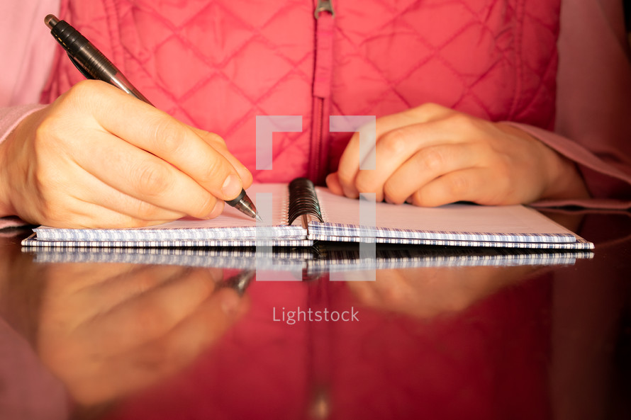 a woman writing in a notebook 