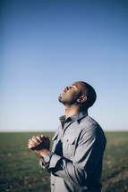 man in prayer with his head lifted towards God