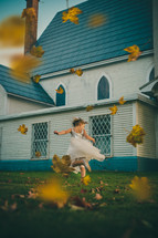 a girl in a dress running in fall leaves 