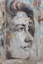 Painting of a woman on a derelict building wall