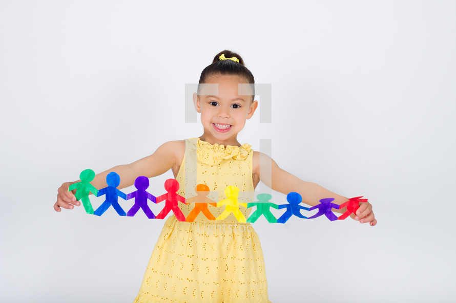 Little girl holding a paper cutout of people.