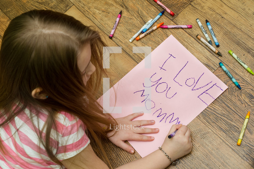little girl coloring an I love you mommy card