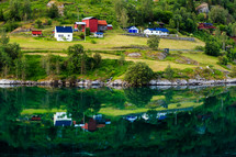 reflection of houses on calm lake water 