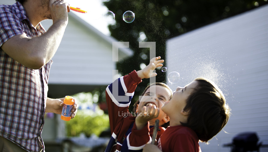 dad and boys playing with bubbles 