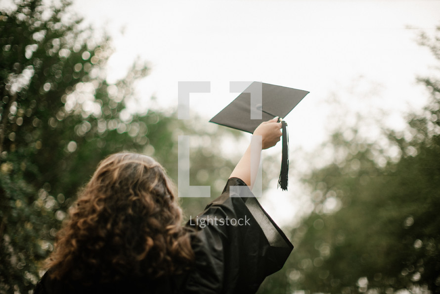 female graduate tossing her graduation cap 
