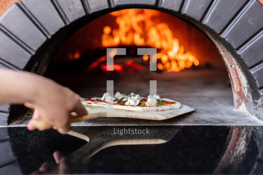 cooking a pizza in a brick oven 