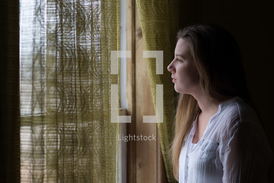 a young woman looking out a window