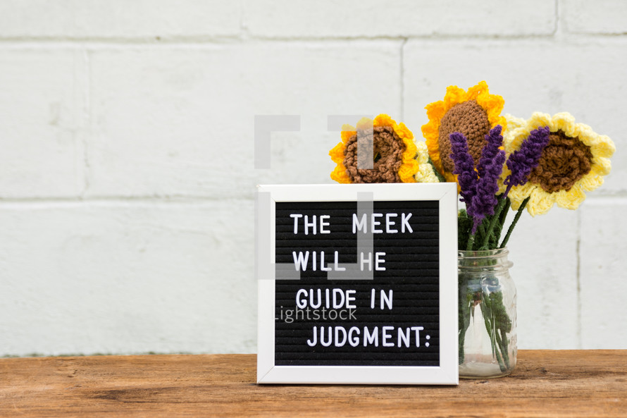 Psalm 25:9 on a letter board with crocheted flowers