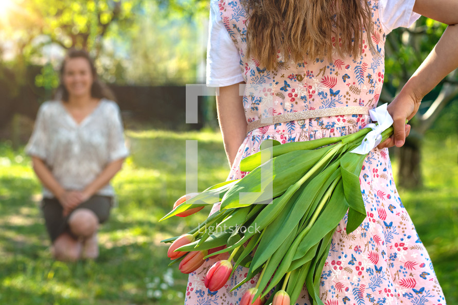 a child giving her mother tulips for mother's day 