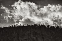 Clouds over Yosemite forest and granite wall