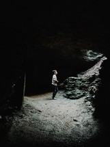 boy standing in a cave 