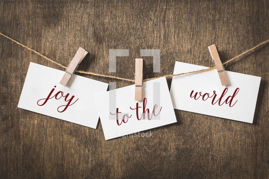 word joy to the world on card stock hanging on twine by a clothespin 