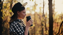 Hipster woman enjoys aroma and taste of fresh coffee