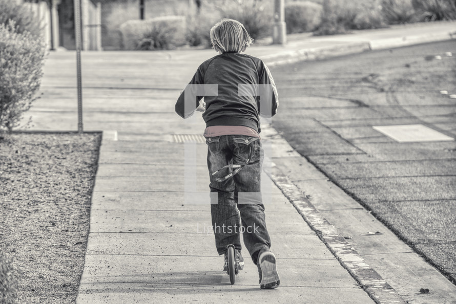 A boy child on a scooter 
