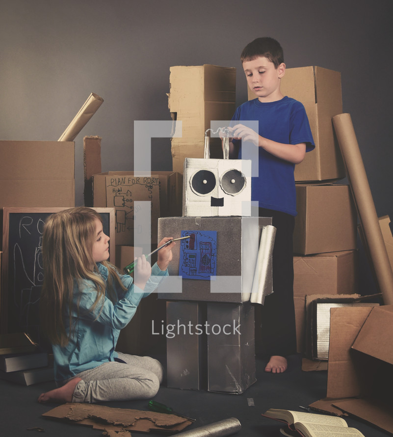 kids making a robot out of cardboard boxes 