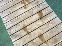 wet footprints on a dock 