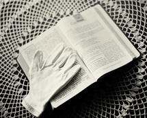 Formal gloves on an open Bible on a lace doily..  