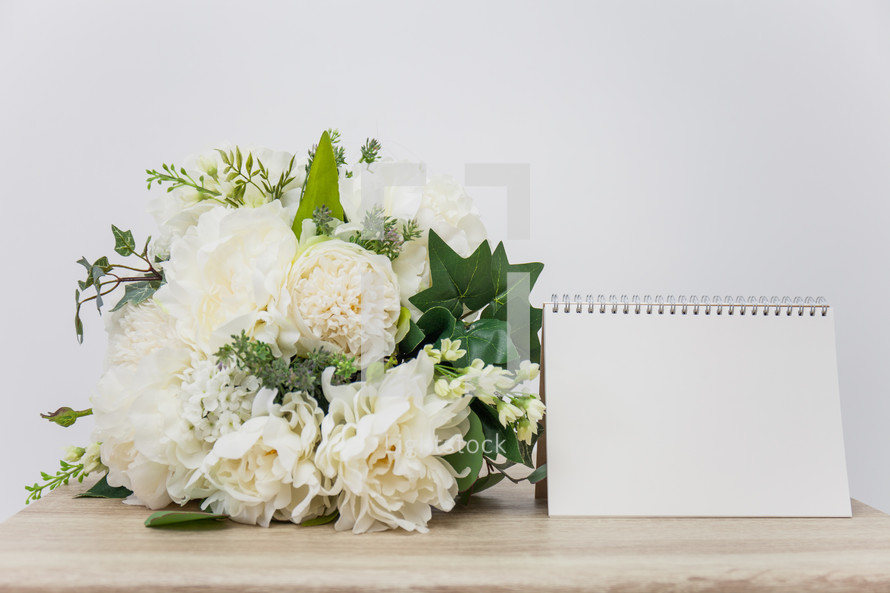 wedding bouquet and blank notepad 
