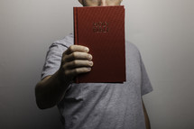 man holding out a Bible in front of him 