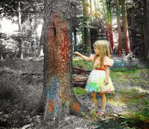 a girl painting a tree 