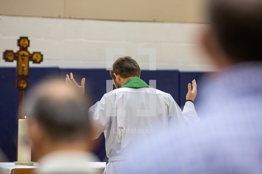 pastor with hands raised during prayers