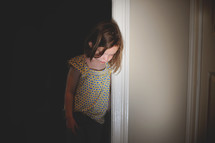 a pouting child in a doorway 