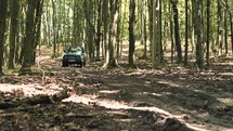 SUV driving through a forest 