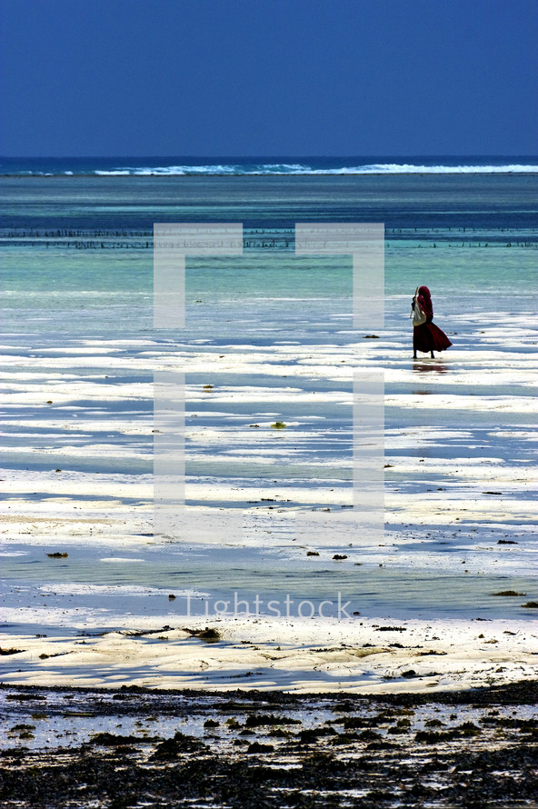 woman standing on a white sand beach, Masai in Zanzibar