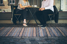 A man and woman sitting at a table drinking coffee
