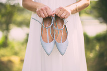 bride holding shoes 