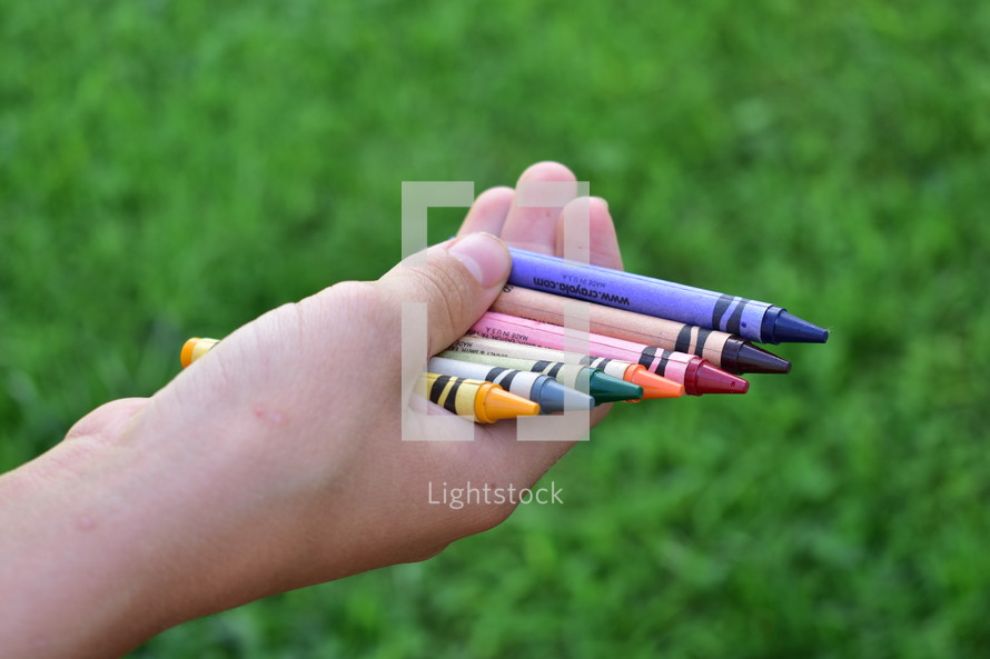 hands holding crayons 