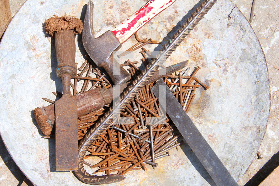 Rusty nails, crow bar and hammer on a mission project