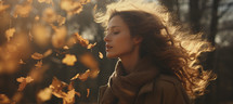 A portrait of a young woman standing near falling leaves with eyes closed