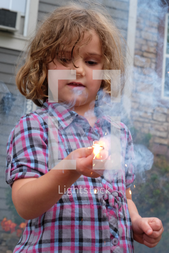 a child holding a sparkler 