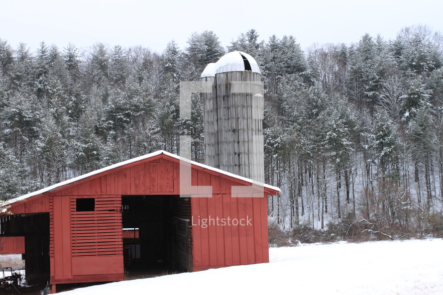 red barn and silo and snow on the ground