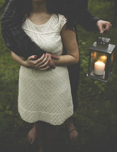 Couple embracing while holding a candle light.