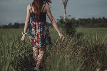 teen girl walking through a field 