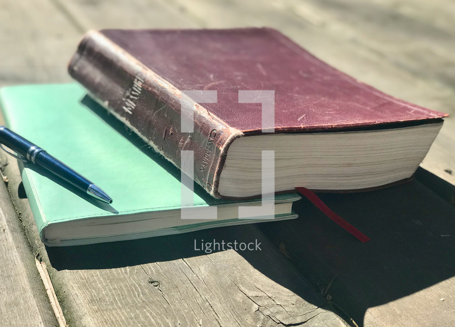 Bible on notebook on a wood deck 