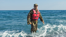 Soldier with life jacket comes out of the sea