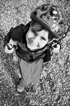 child on a swing wearing a bike helmet