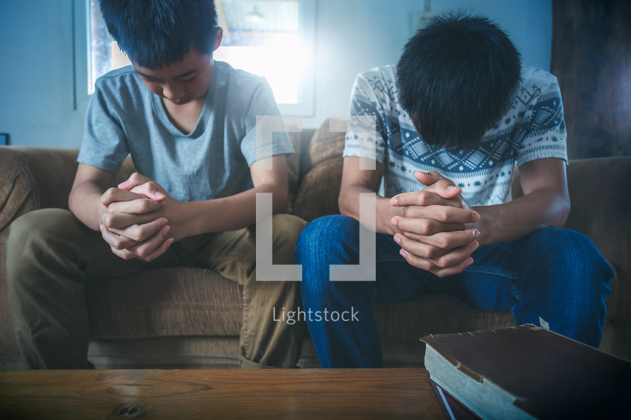 boys praying over Bibles 