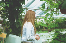 a woman walking into a greenhouse 