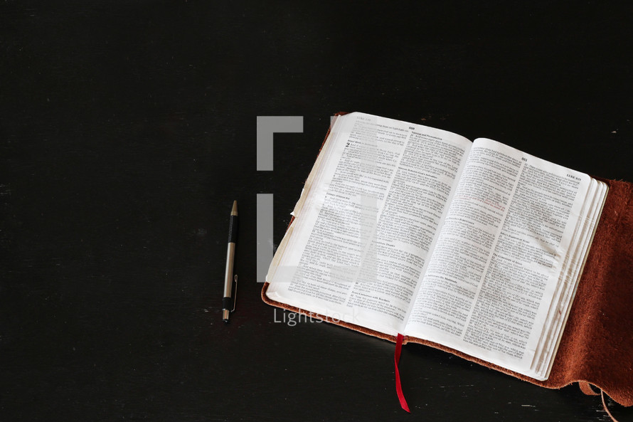 open Bible and pen on a table 