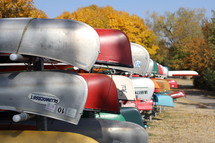 stacked canoes along a shore 