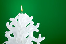 Christmas candle shaped like a Christmas tree on green background
